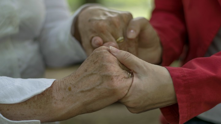 Two people holding hands while discussing how to prepare for retirement.